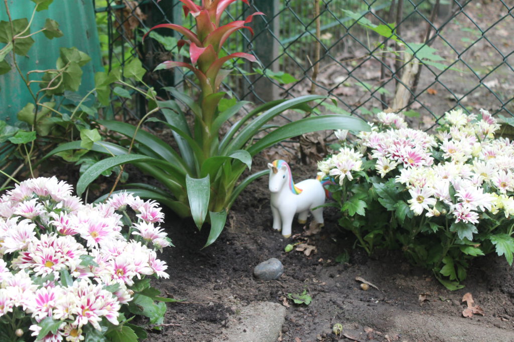Blühendes Gartenbeet mit Figur